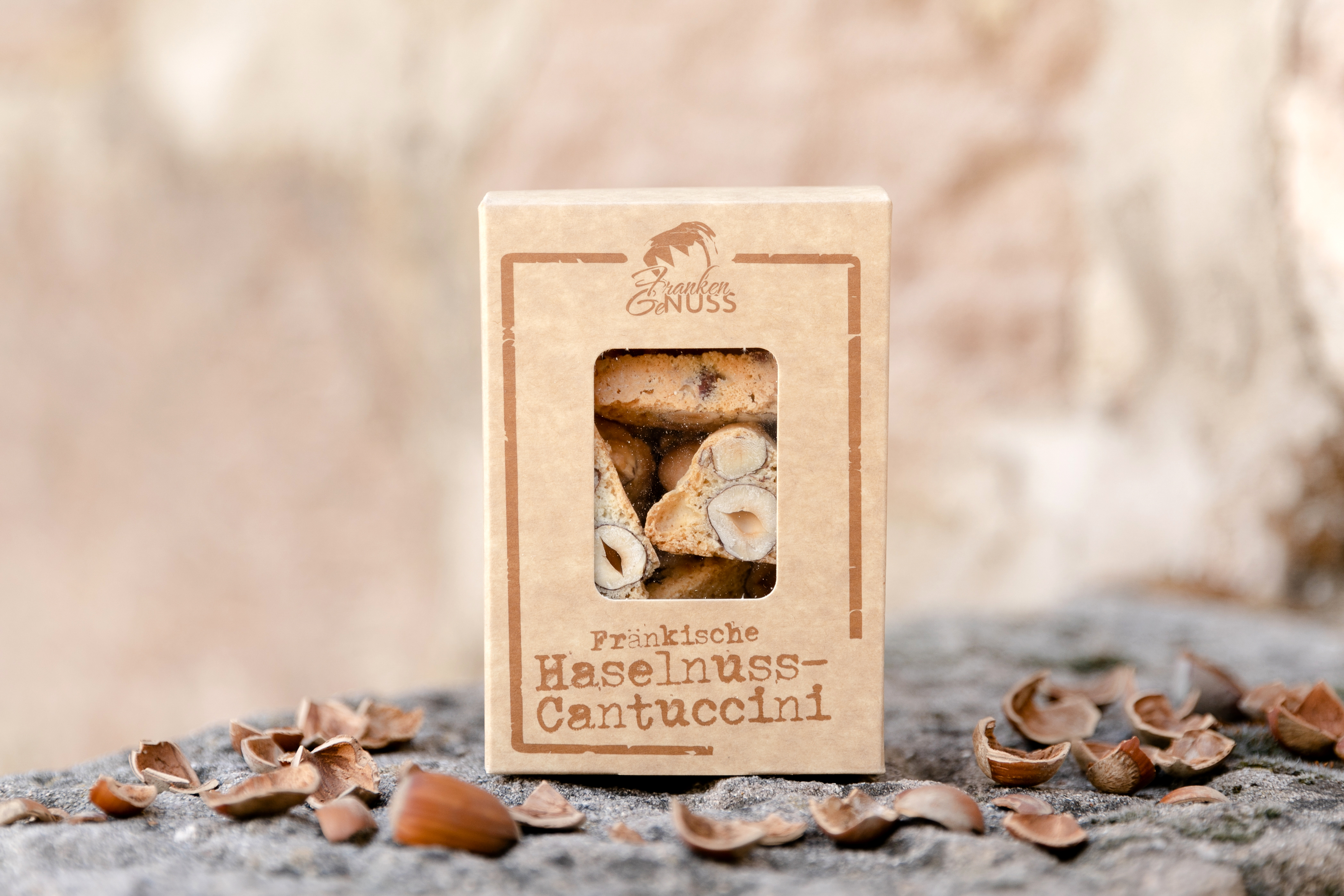 Knusprige Haselnuss-Cantuccini in einer dekorativen Geschenkbox, umgeben von Haselnüssen und Nussschalen auf Stein. Knusprige Haselnuss-Cantuccini in einer dekorativen Geschenkbox, umgeben von Haselnüssen und Nussschalen auf Stein.