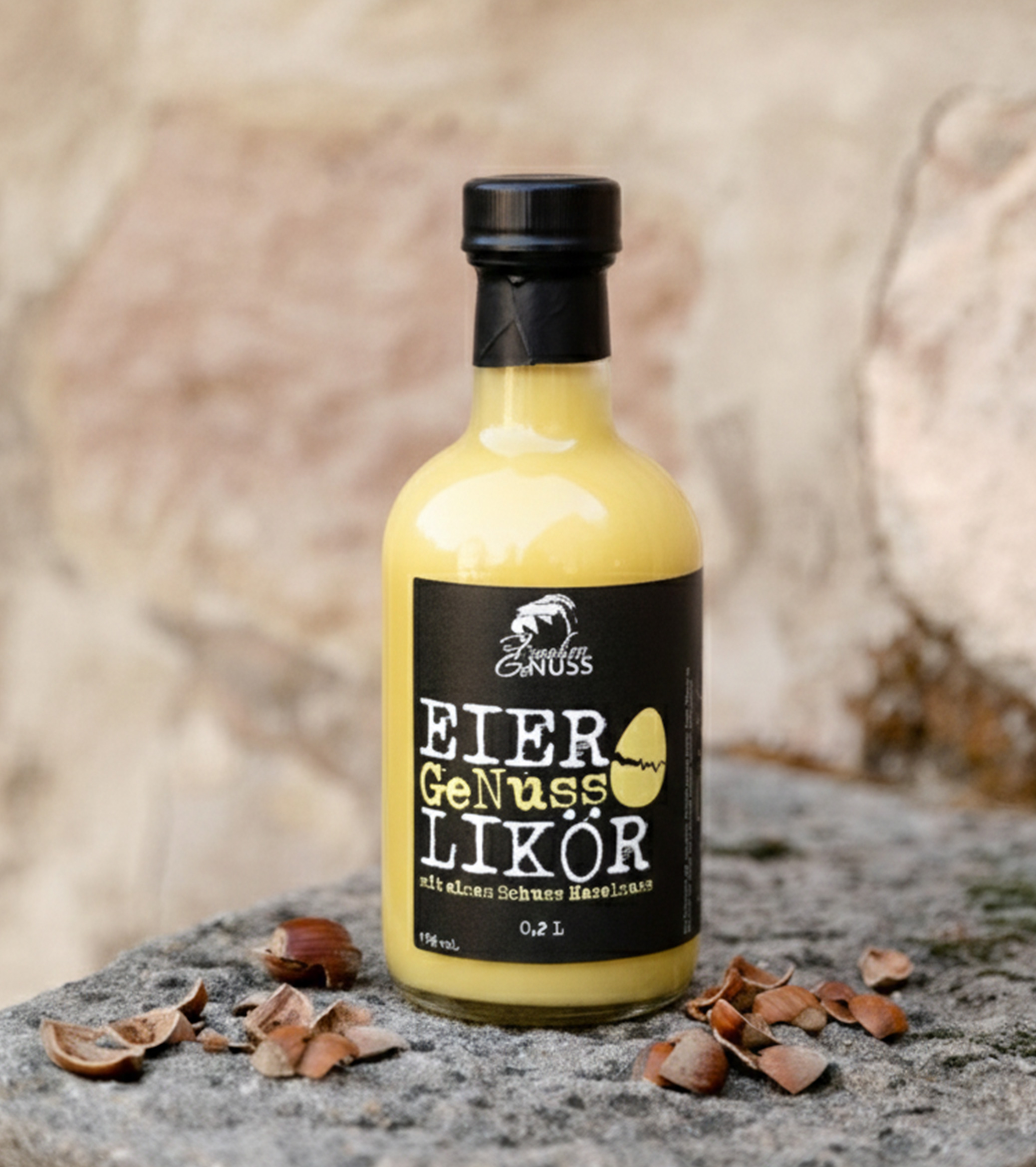 Eine kleine Flasche gefüllt mit gelbem Likör steht auf einer Steinplatte, umgeben von Nusschalen.